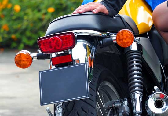 Why do motorcyclists flip their plates?